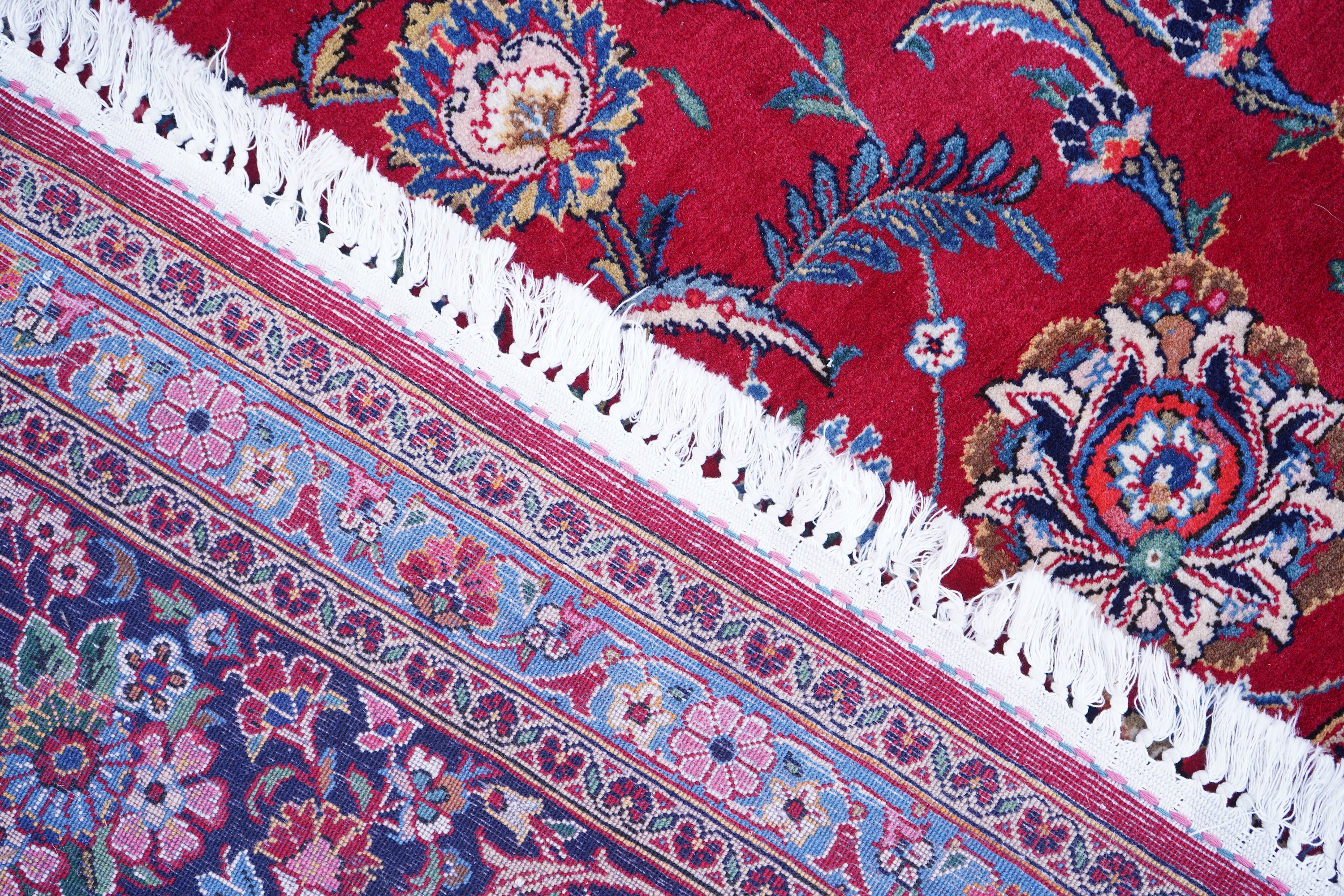 A Kashan burgundy ground carpet
